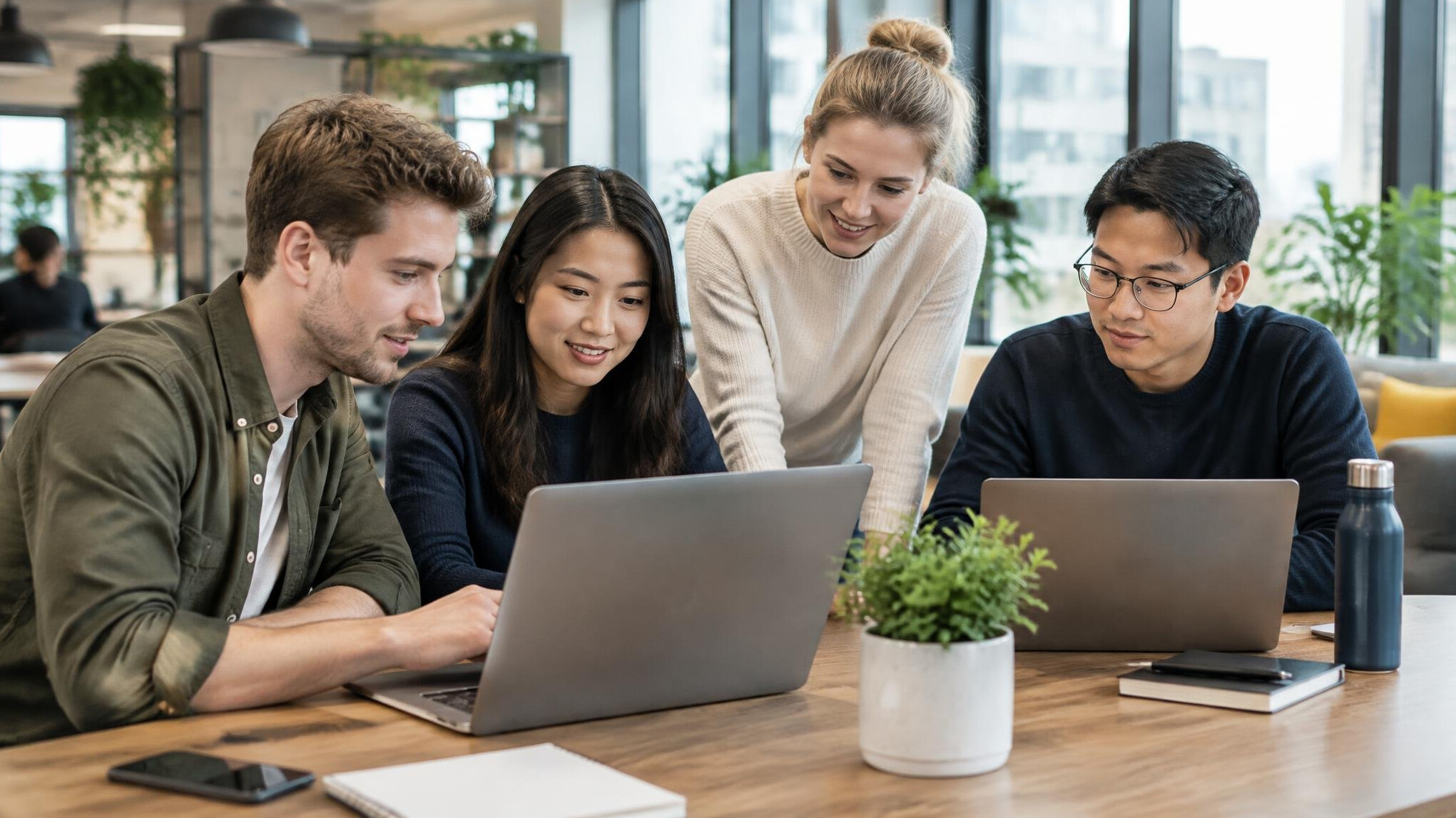 Team members working on laptops in a modern workspace